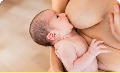 An infant being held and supported during breastfeeding.